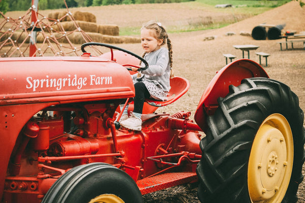 A child riding a tractor at a family farm attraction
