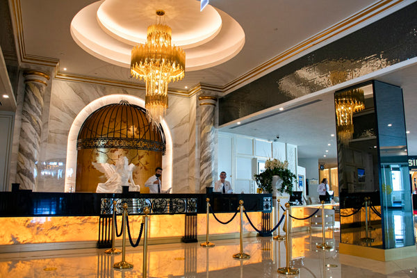 An ornate gold chandelier on a white coffered ceiling in a luxury hotel interior